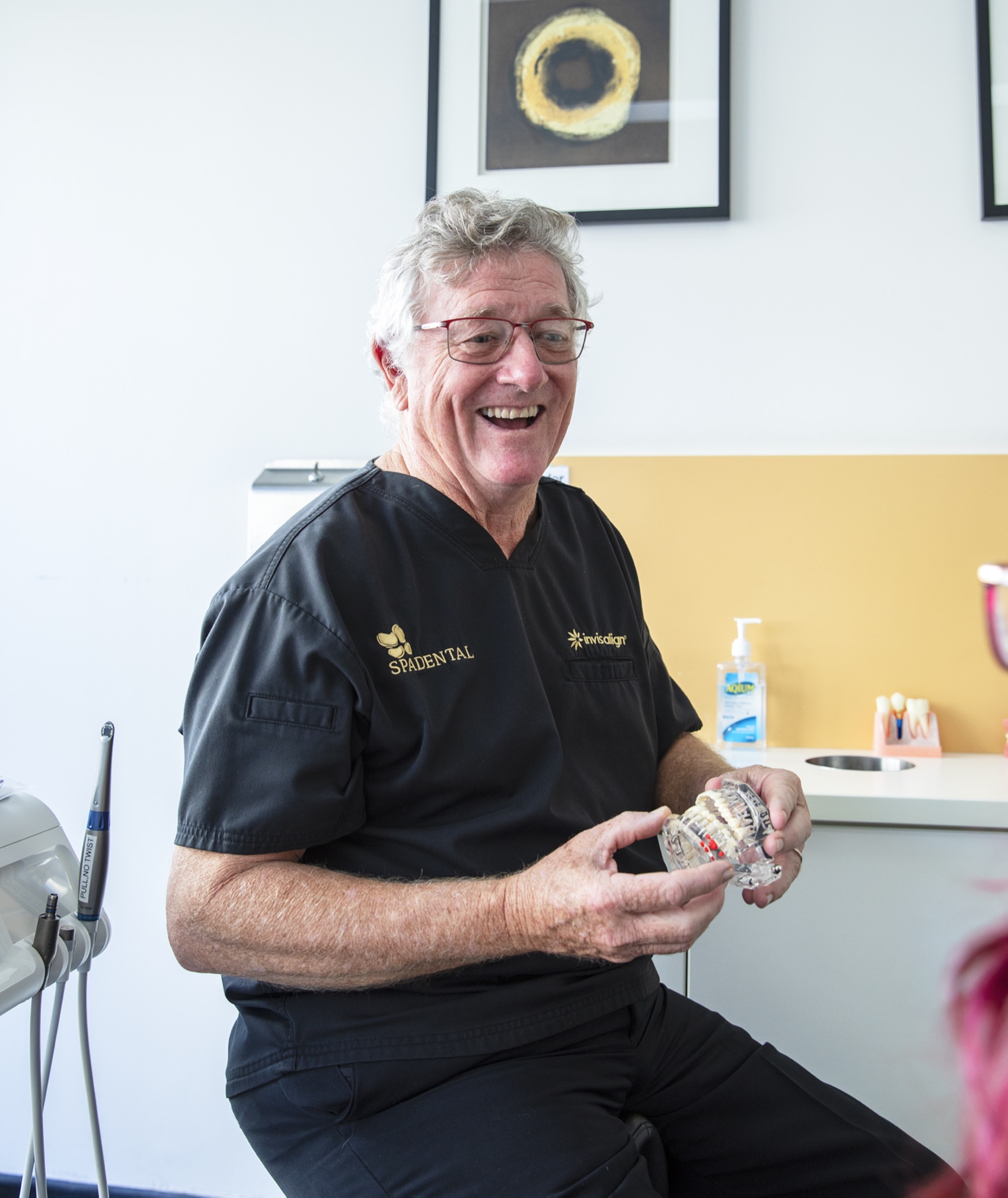 A Spa Dental dentist holding a dental study model during a consultation