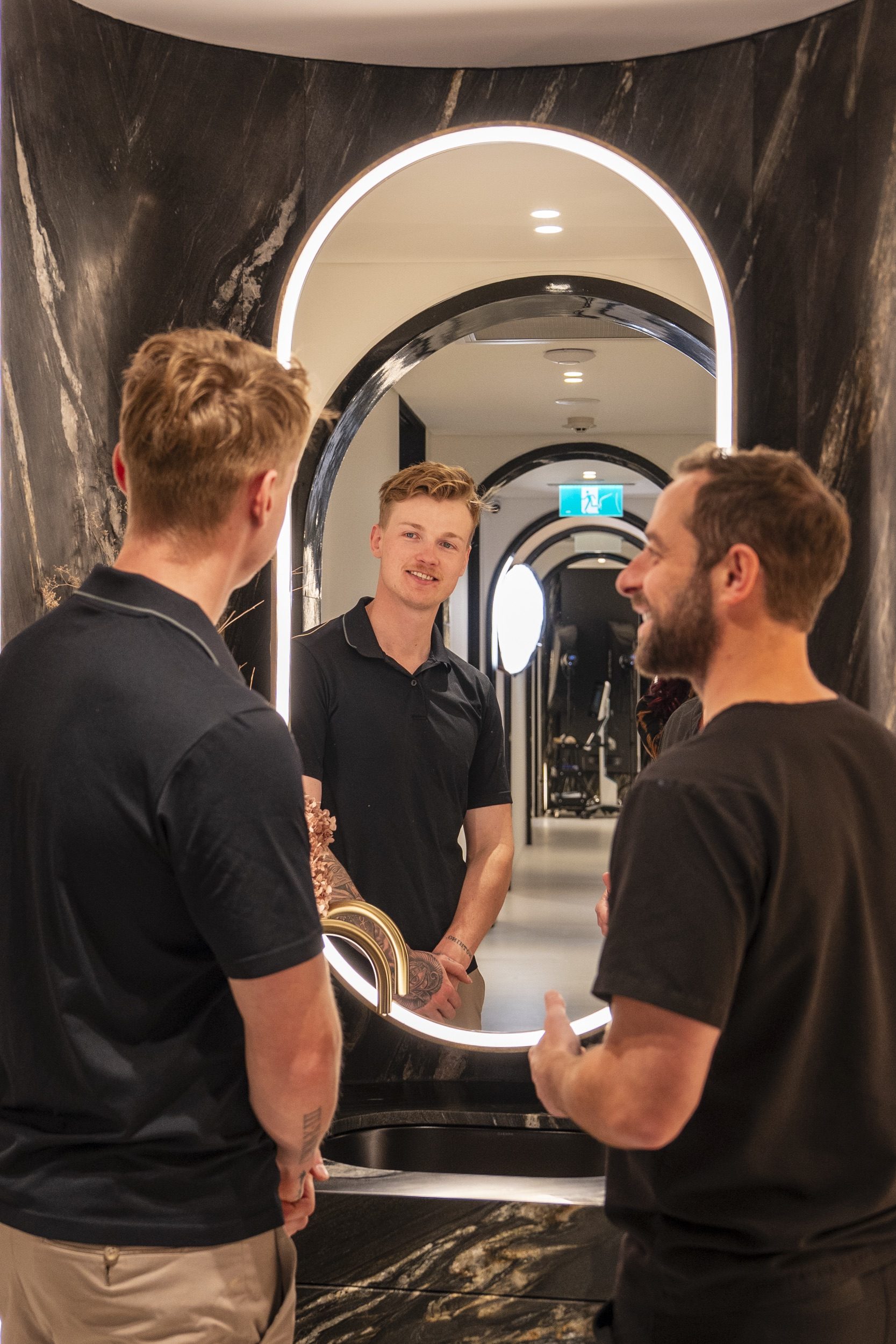 A patient seeing his new smile in the mirror with his dentist beside him