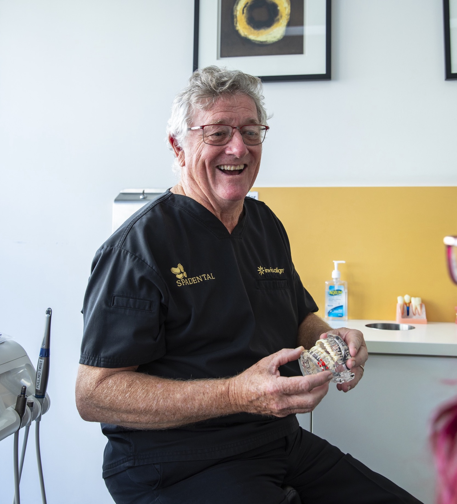 Dr Lawrence Neville holding a full-arch implant model at Spa Dental Sydney CBD