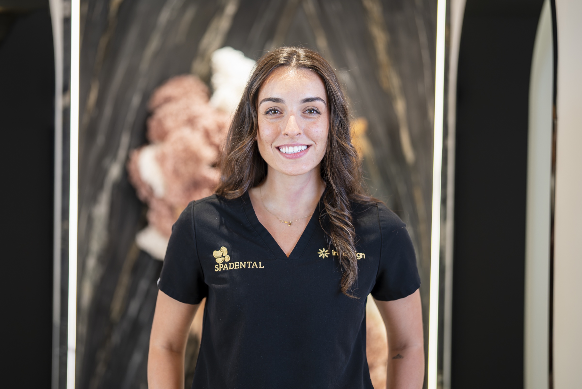 A Spa Dental clinician in the clinic, smiling to camera