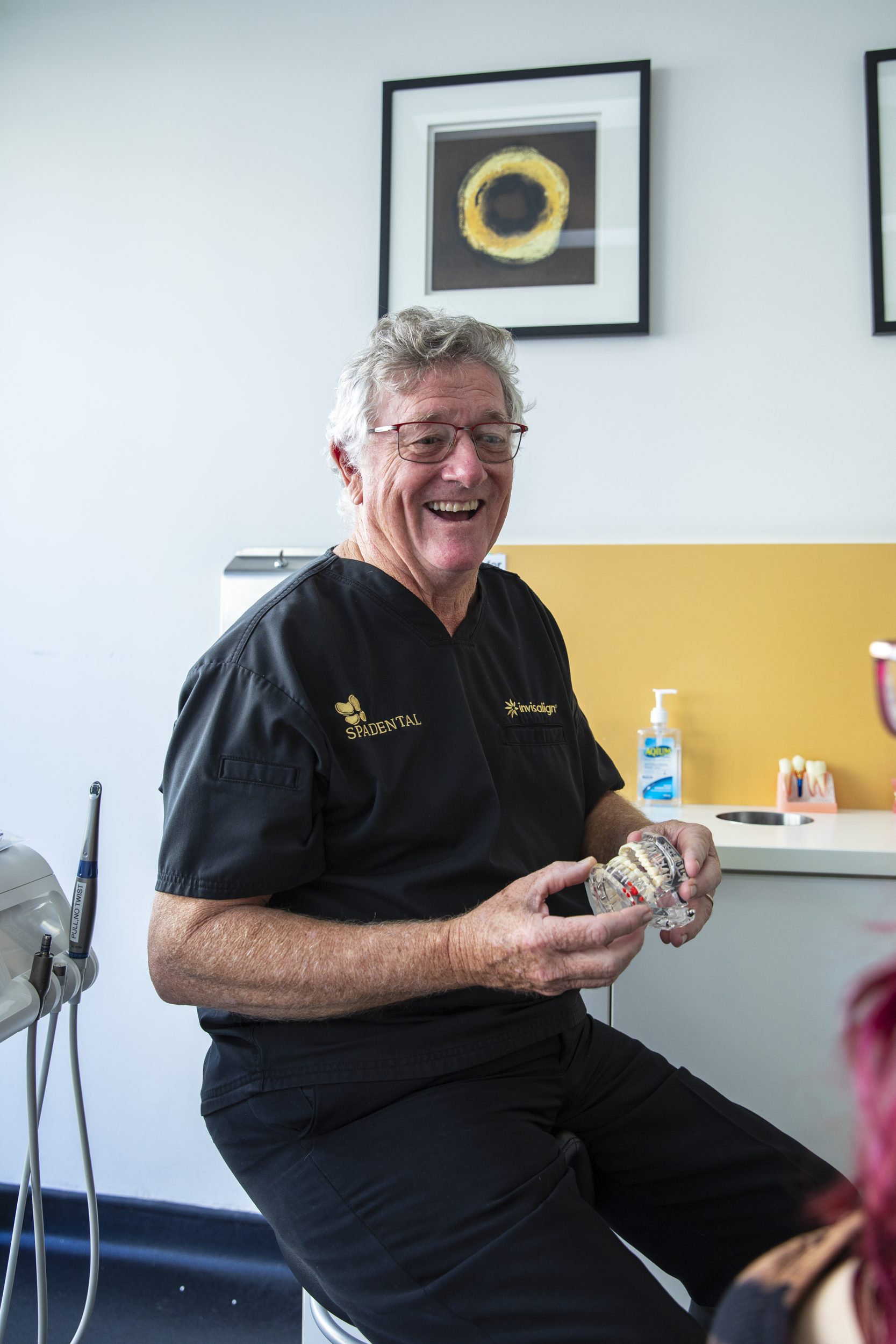 A Spa Dental dentist explaining treatment to a patient with a model of the jaw